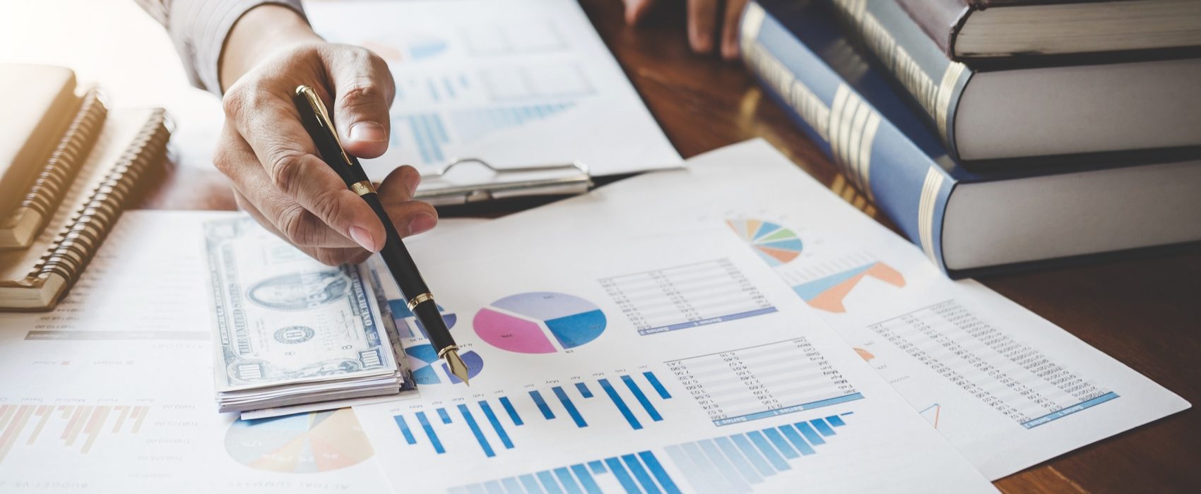 Businessman pointing at graph and chart to analysis use for plans to improve quality, business finances and accounting concept.